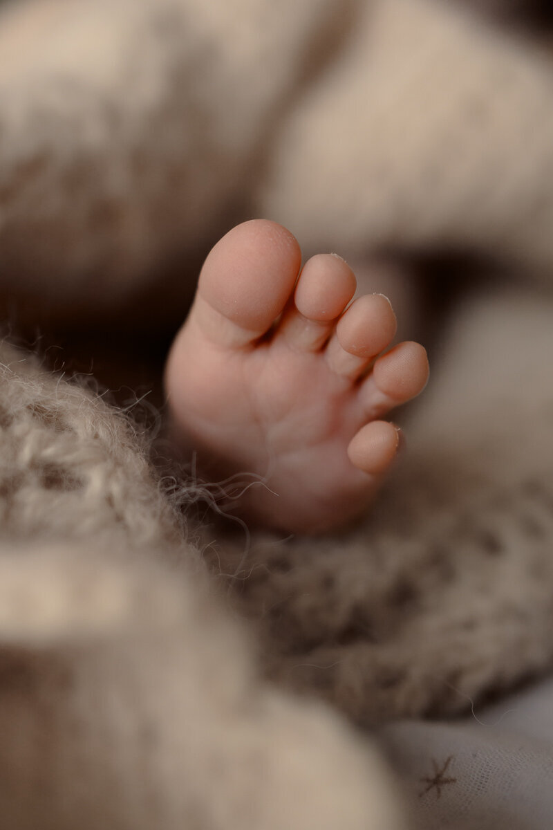 detailfoto van een voetje van een baby tijdens een newbornshoot