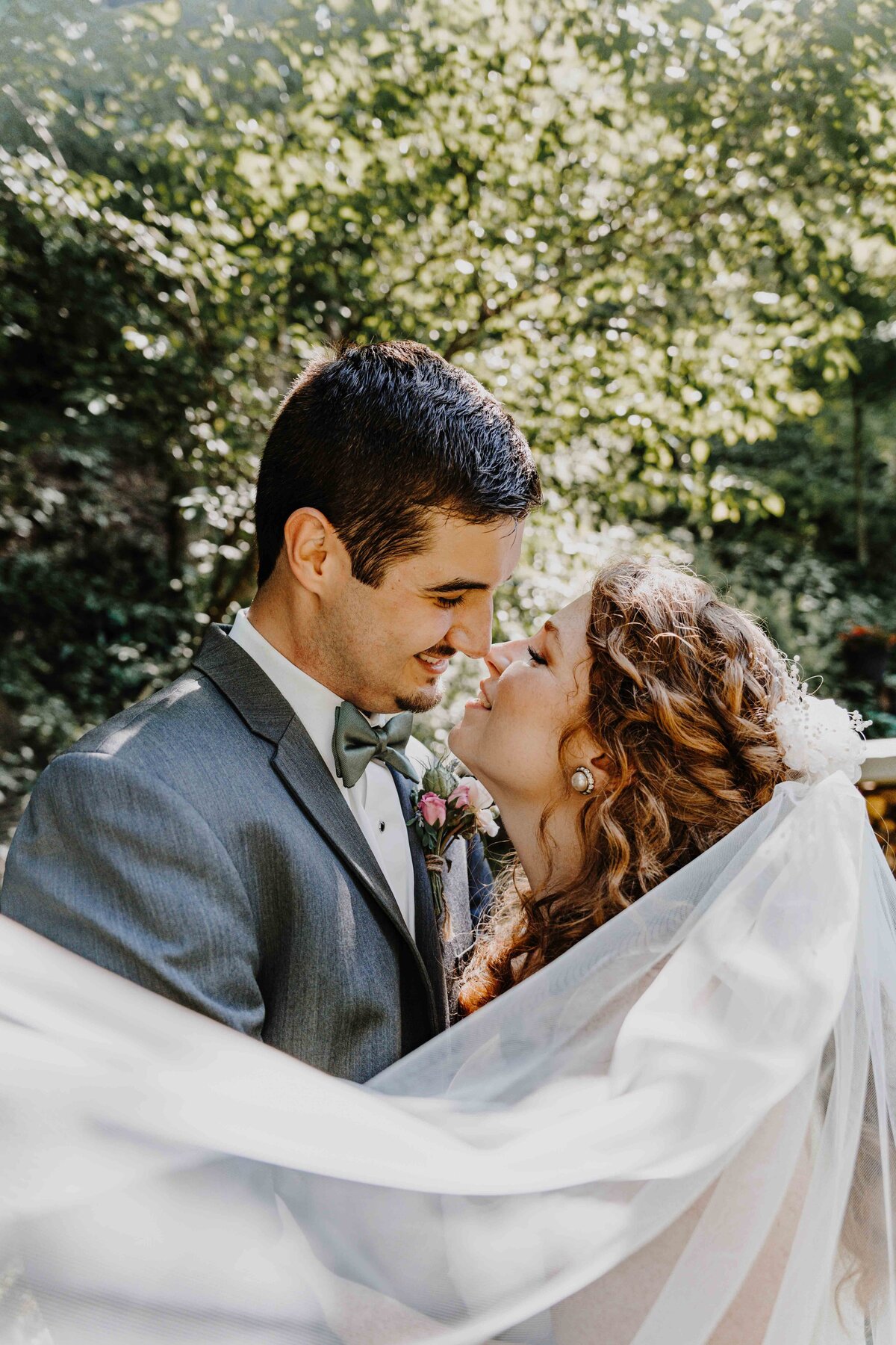 newlyweds embracing with veil surrounding