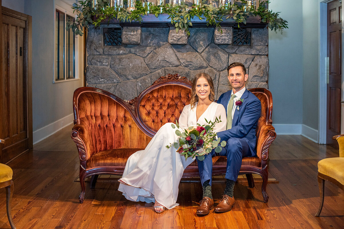 Wedding couple sitting on vintage couch at Homewood Asheville