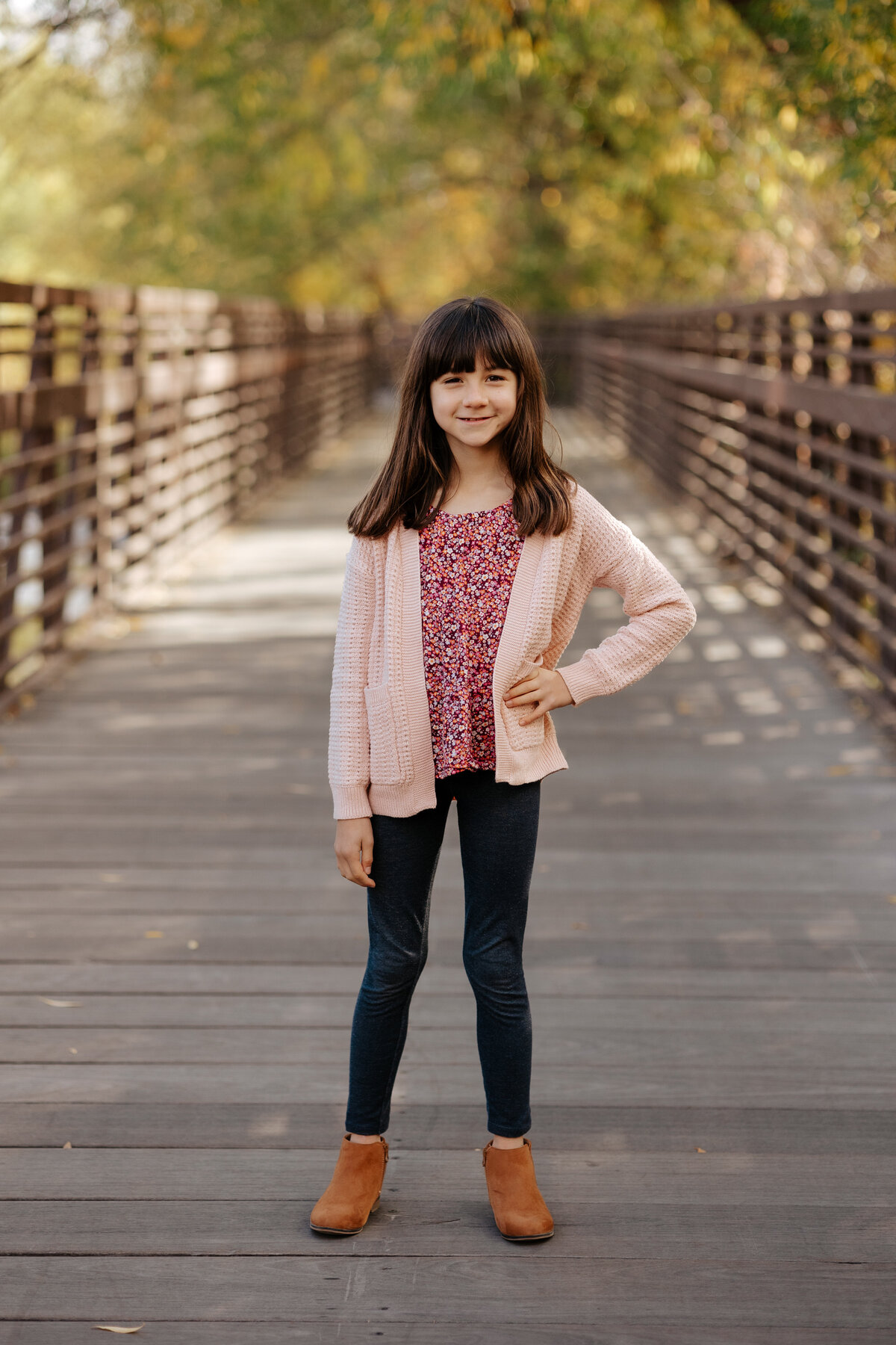 A young girl poses for a photo with her hand on her hip during a portrait session in Fort Collins, Colorado.