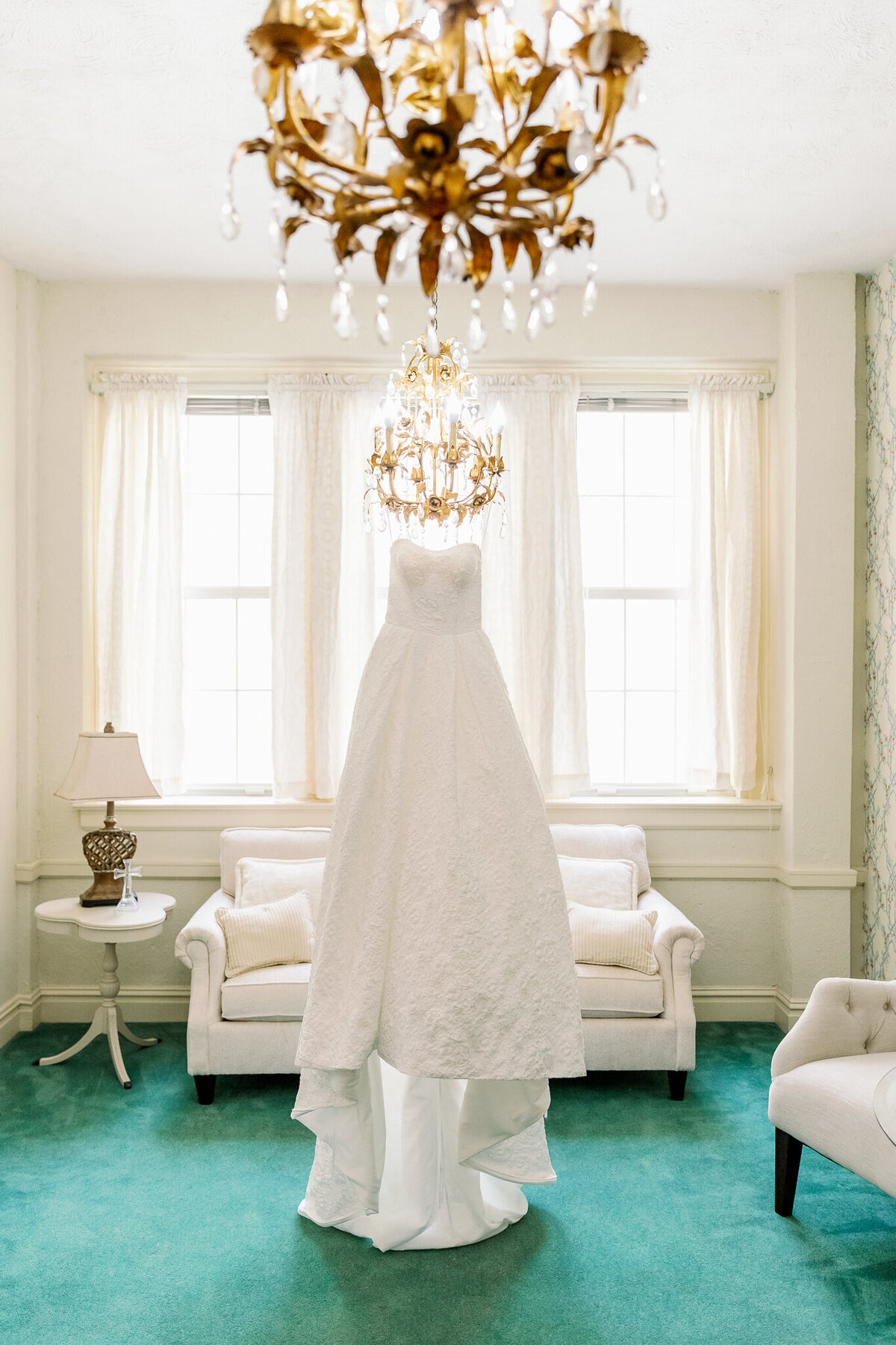 Beautiful wedding dress hanging in the bridal suite as she gets ready