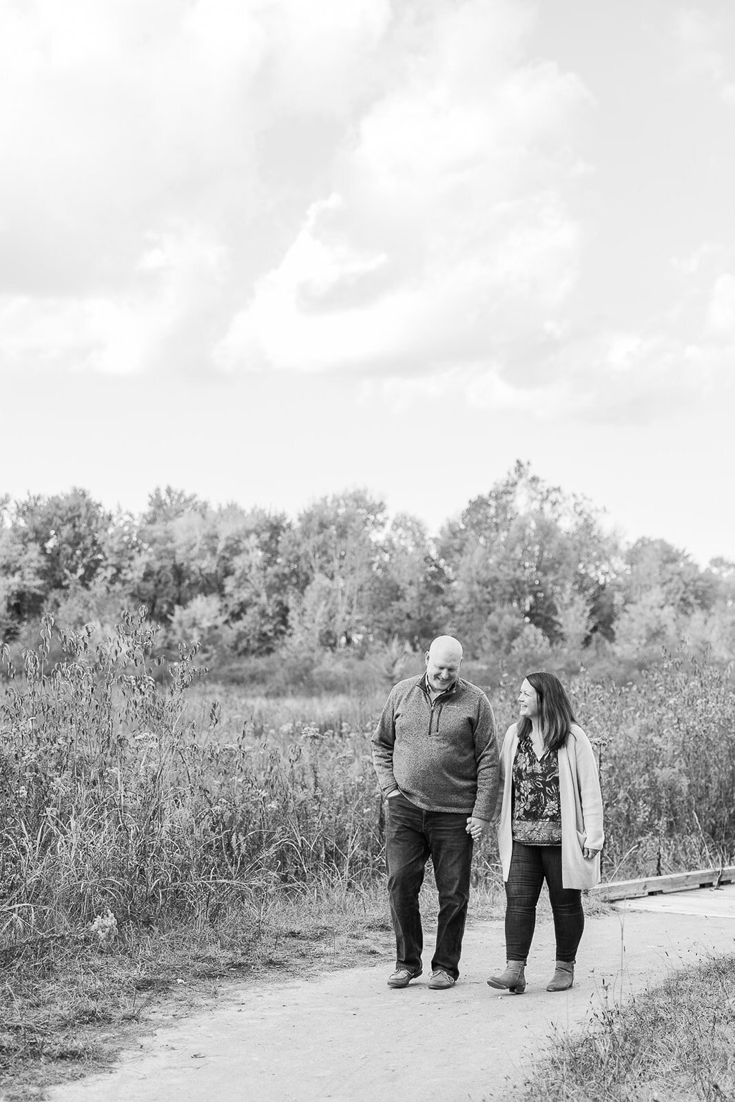 Husband and wife walking hand in hand on a walk path