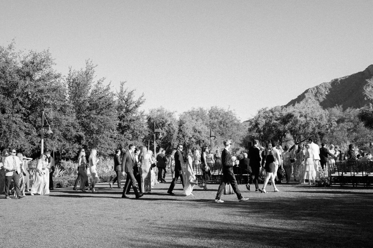 Wedding guests mingling outdoors beneath the Arizona sun with mountain views, captured by Arizona wedding photographers at El Chorro.