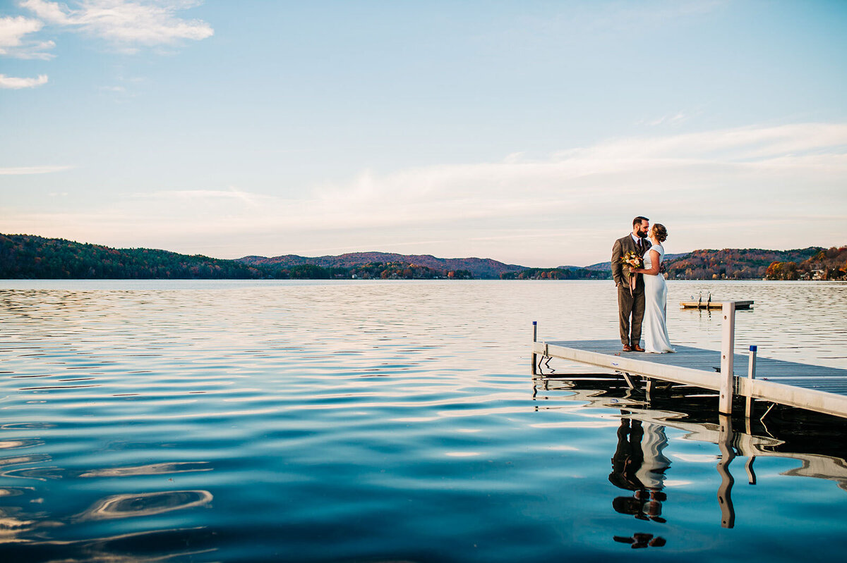 lake bomoseen lodge couple kissing on dock at sunset in front of water