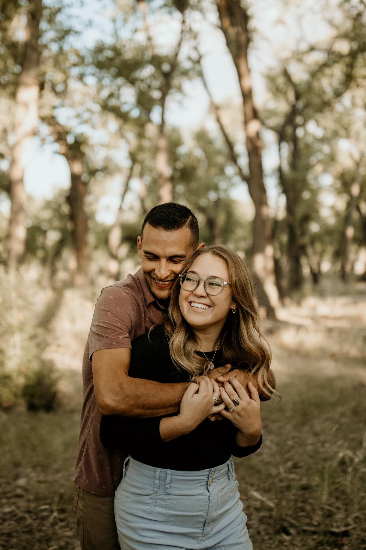 engaged couple holing each other laughing at the Bosque in Albuquerque