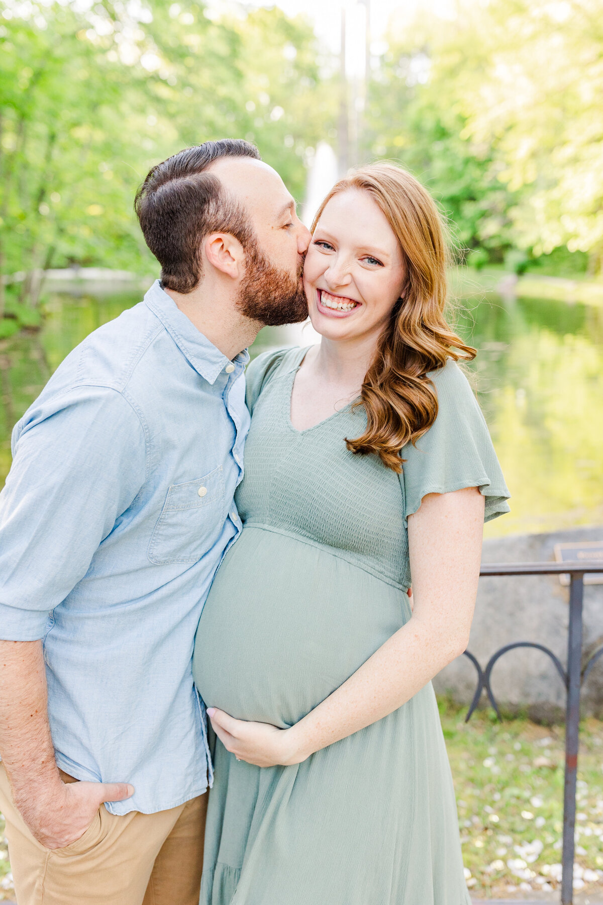 man kissing his pregnant wife on the cheek