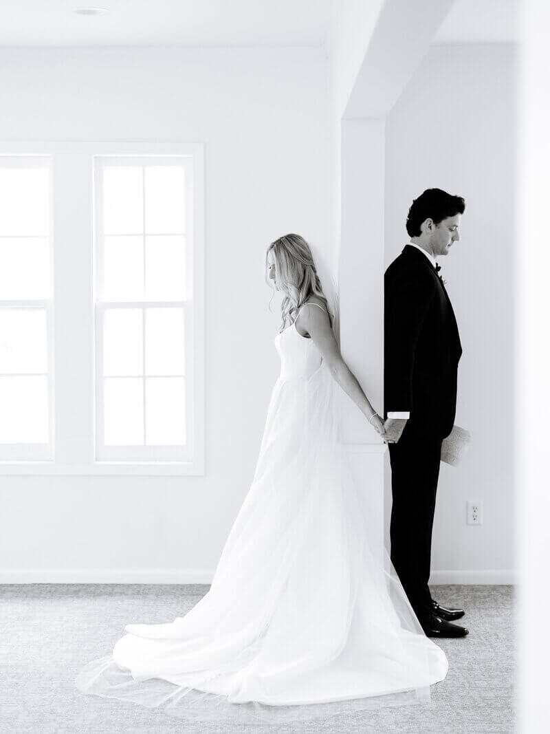 Bride and groom holding hands behind door by chicago wedding planners