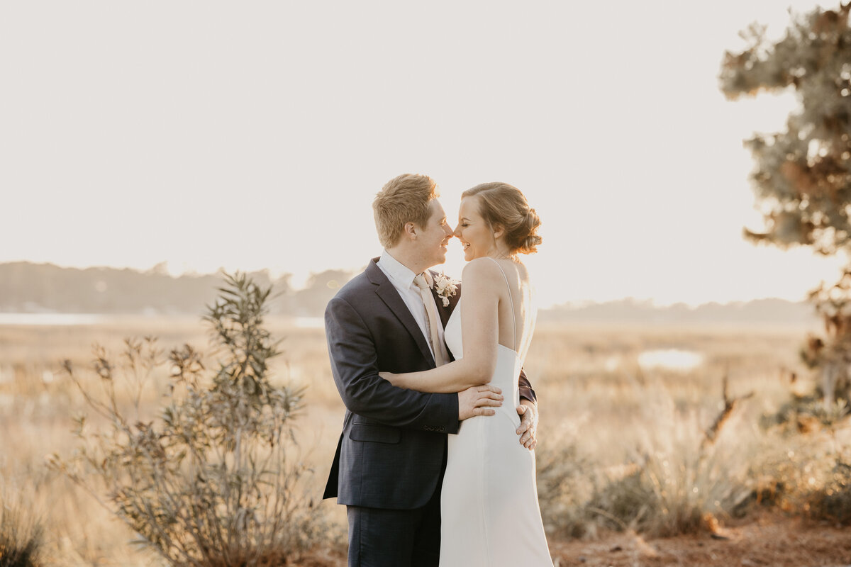 Couple kisses at sunset during wedding day.