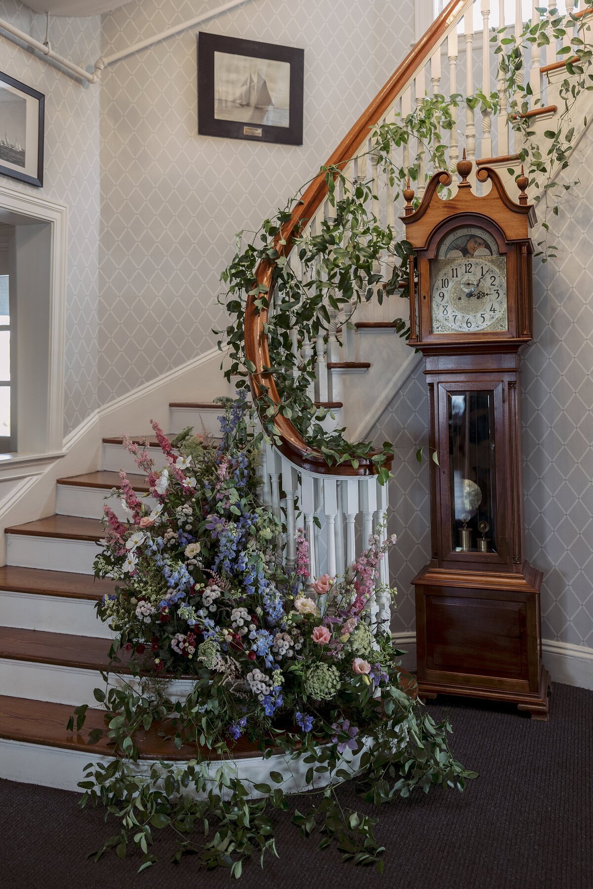 Florals and greenery displayed on staircase at Corinthian Yacht Club.