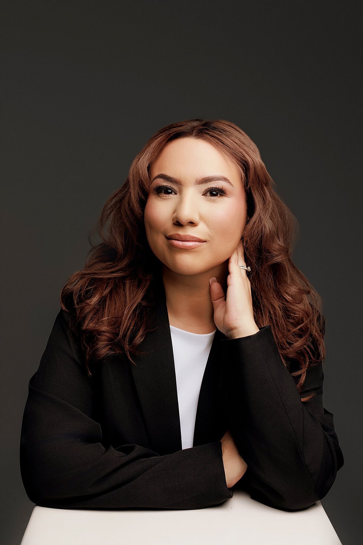 High-end studio portrait for corporate use, photographed with soft backdrop and flattering pose