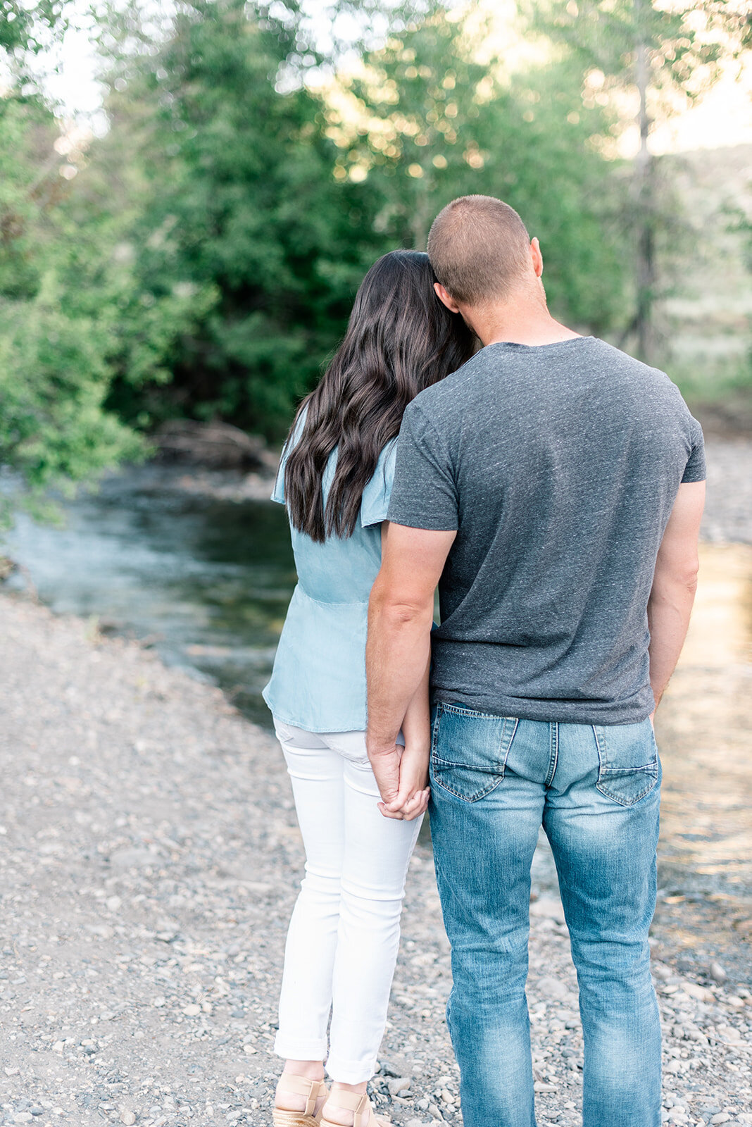 Couple cuddling next to river at Sun Valley Engagement Session with the Best Sun Valley Wedding Photographers