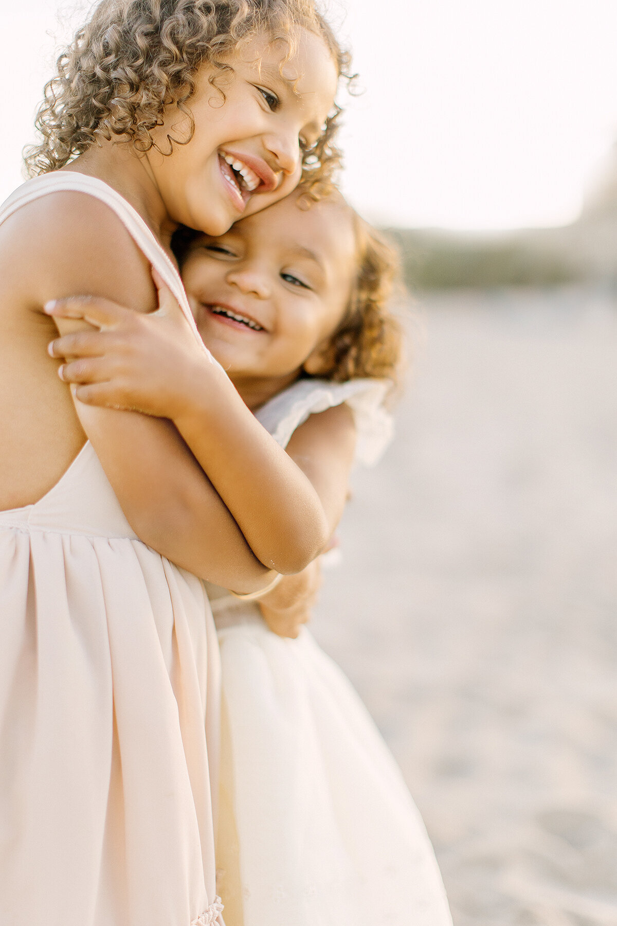 Sisters laughing and hugging by Kansas City photographer Jeanna Hayes