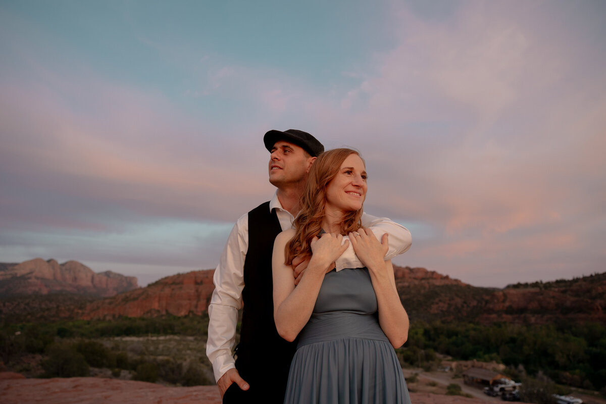 Couple standing against red rock backdrop during Sedona engagement session