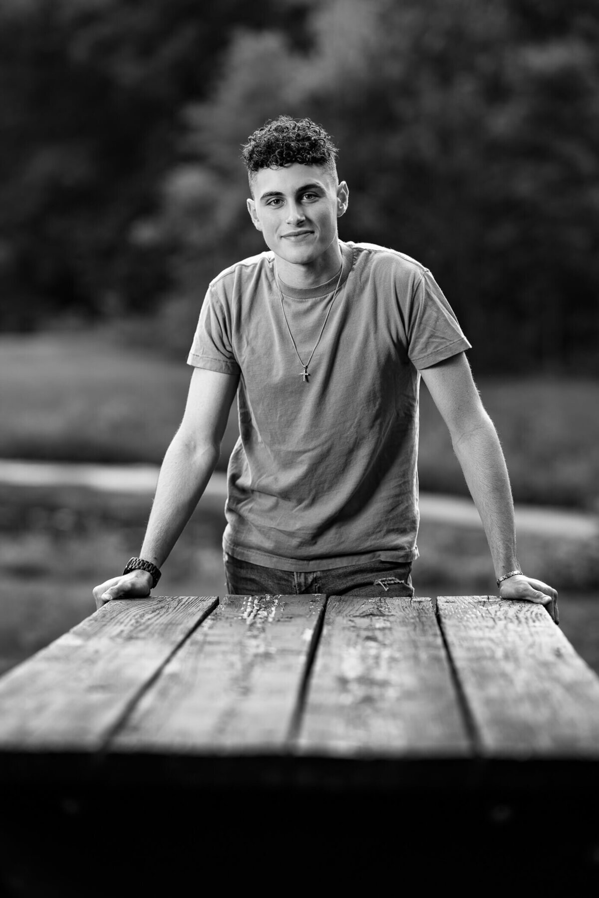 black and white senior photography of a senior leaning over a picnic table at a local park near Beaver County PA