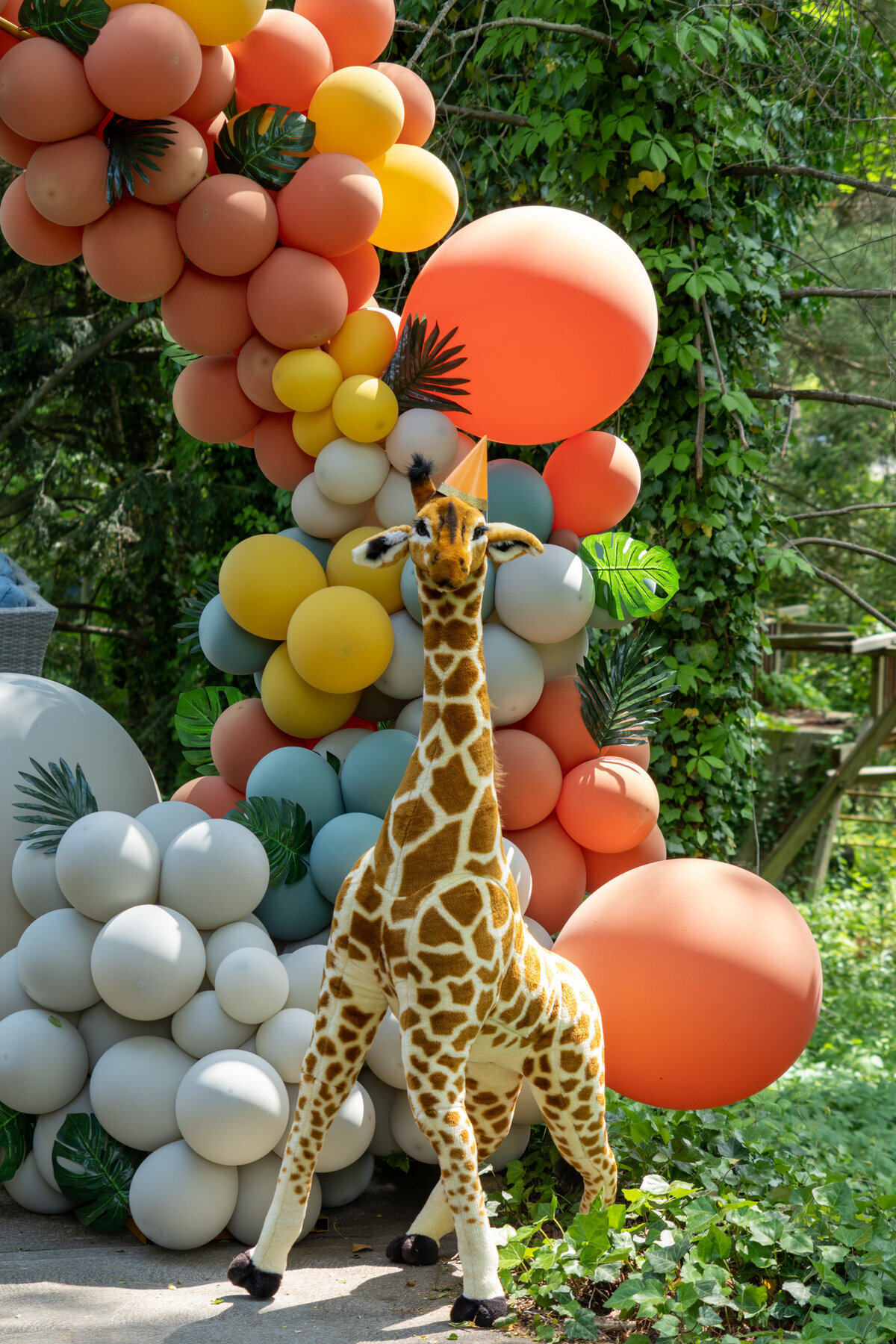 Huge balloon arch for safari themed birthday with oversized giraffe