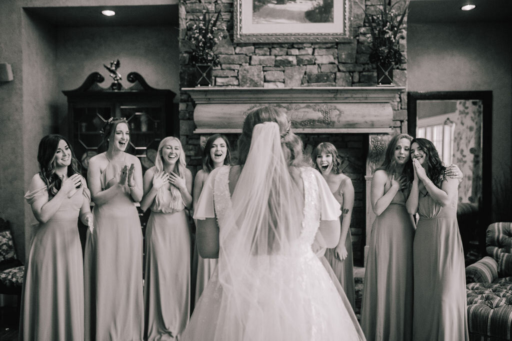 bride shows her bridesmaids her wedding dress for the first time at marblegate wedding venue in friendsville tennessee