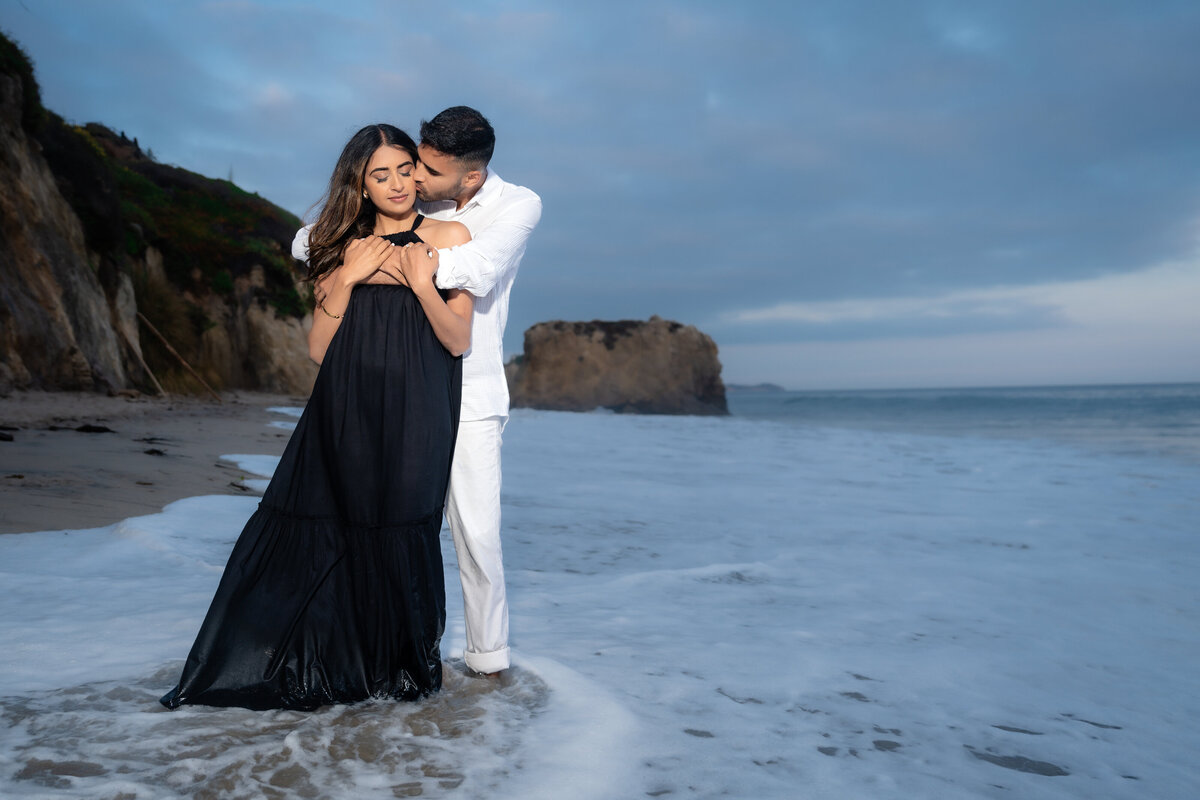 Indian couple eloping at El Matador State Beach in Malibu during low-tide sunset and blue hour kissing.
