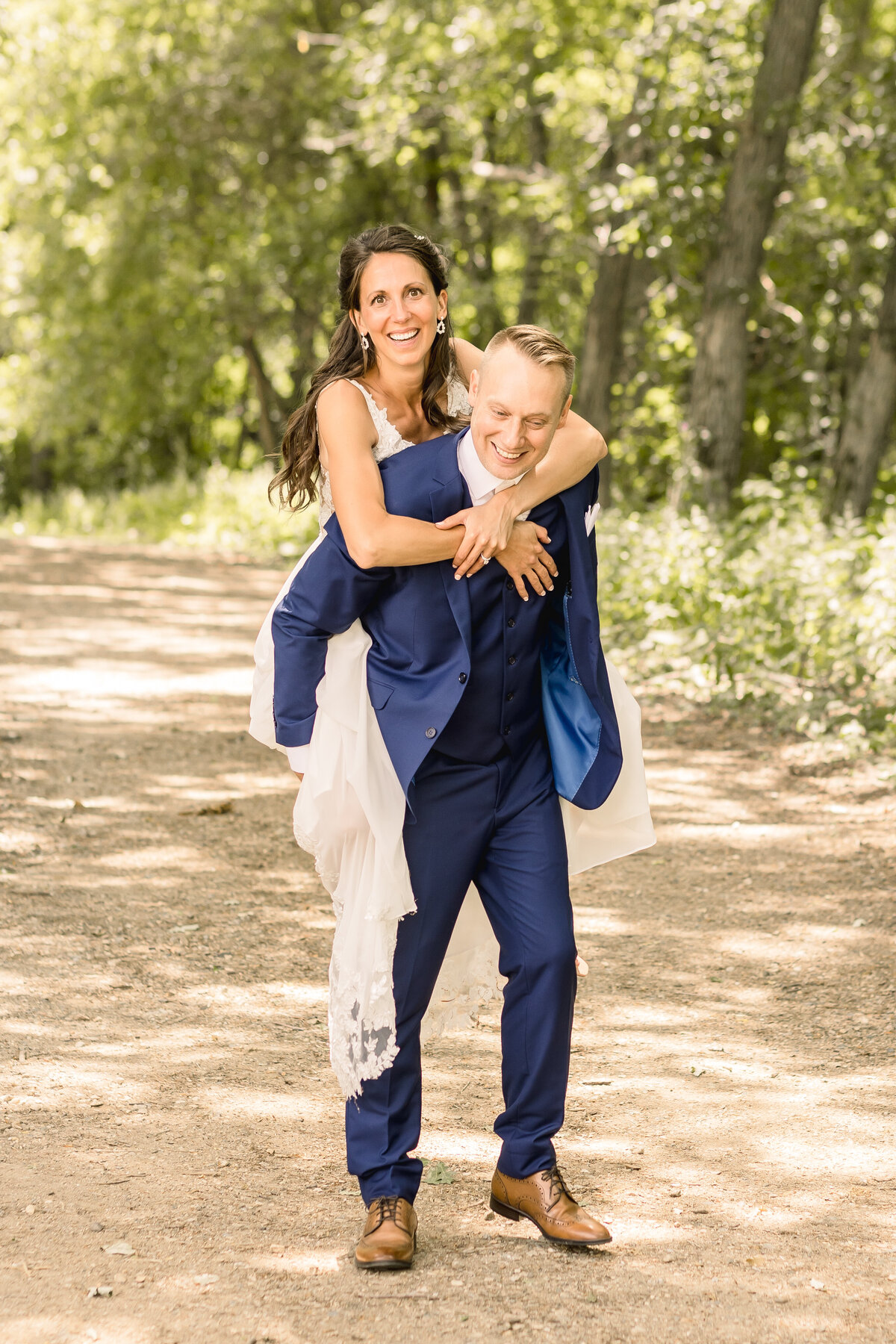 Bride and groom doing a fun piggy back pose on their wedding day