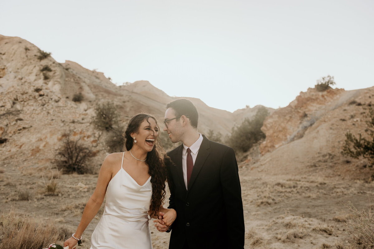 bride and groom walking through a colorful canyon in Rio Rancho, NM