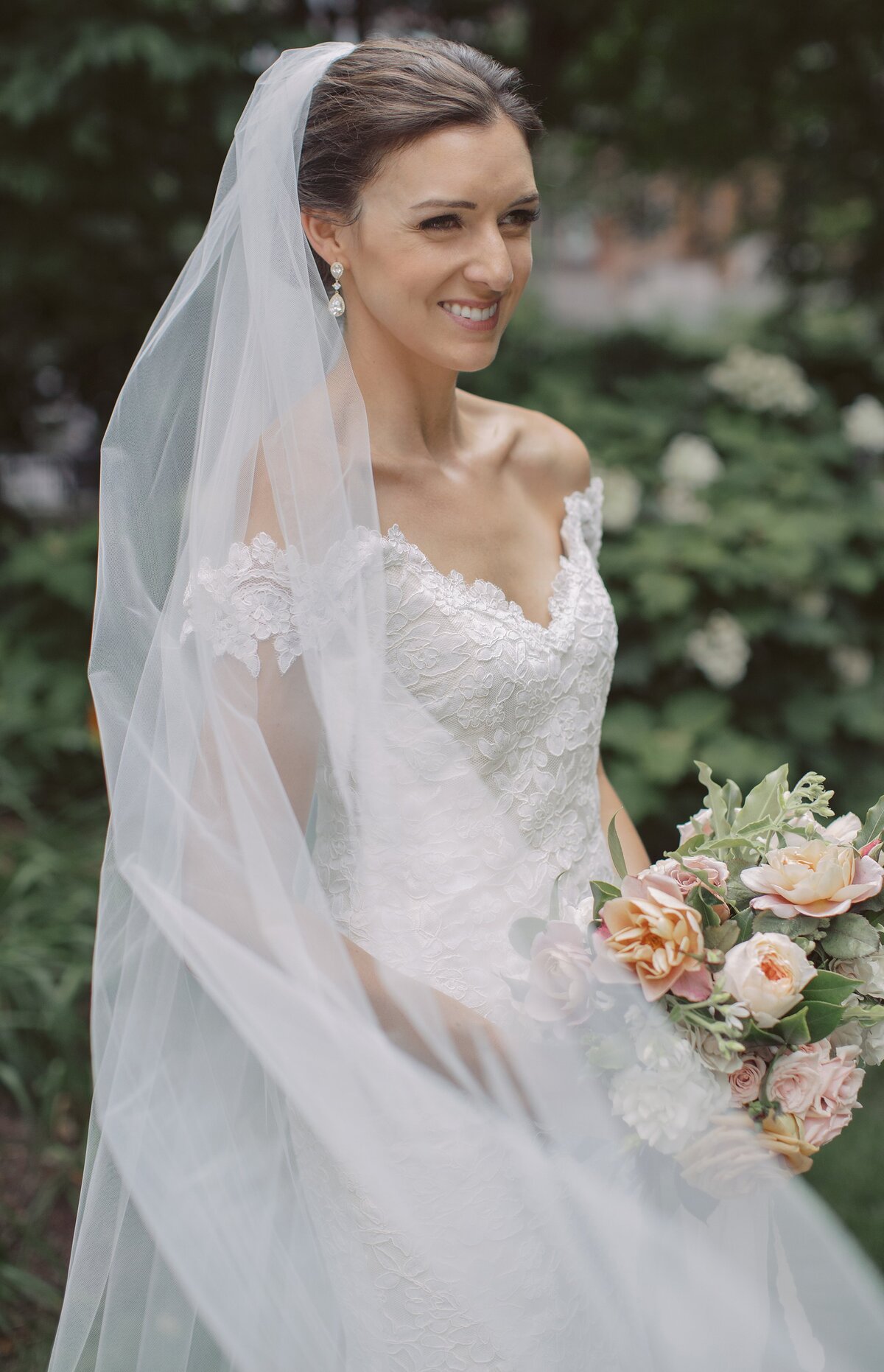 Bride poses with veil during Boston wedding.