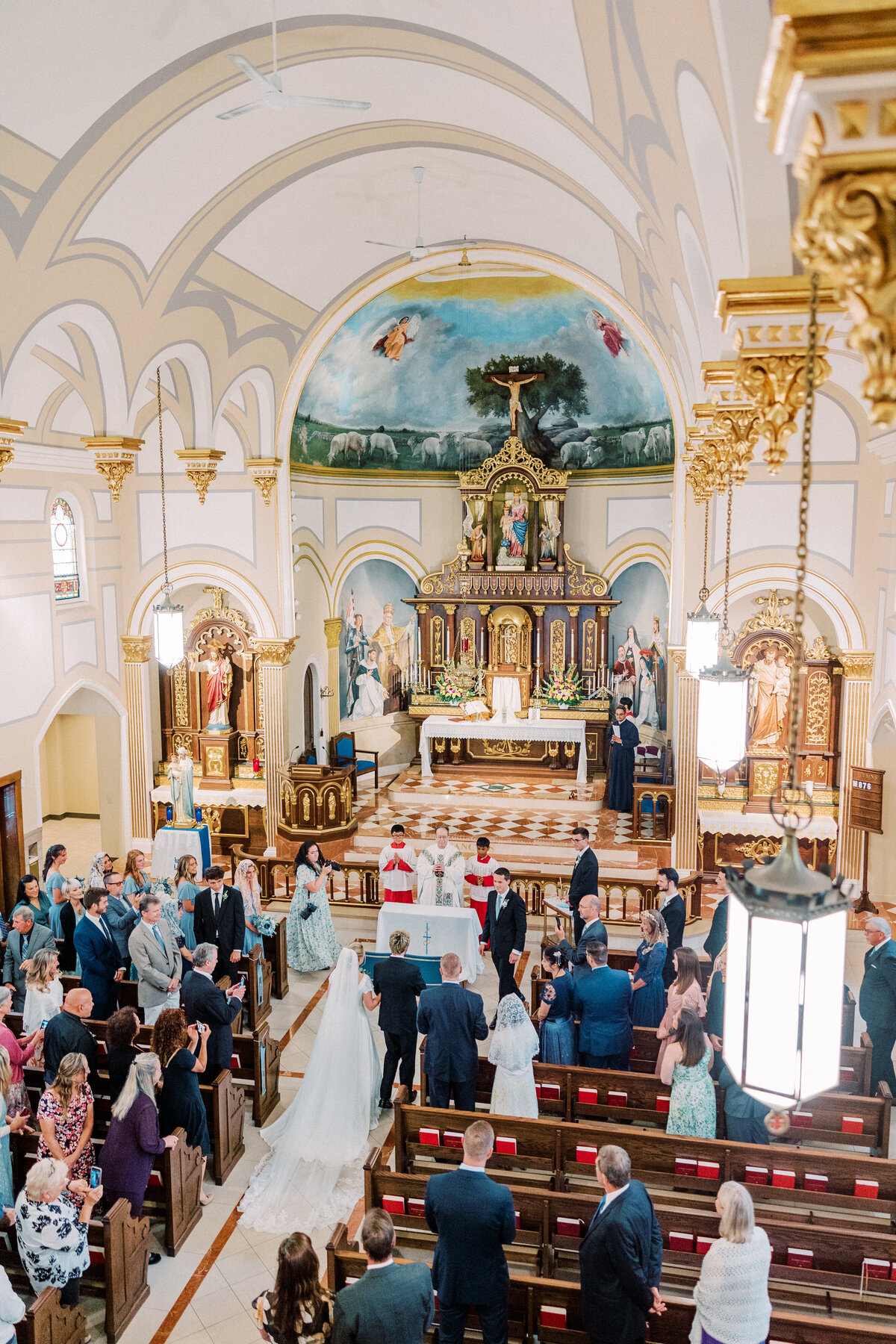 Bride, groom, and guests standing during Our Lady Of Victory wedding in Rochester
