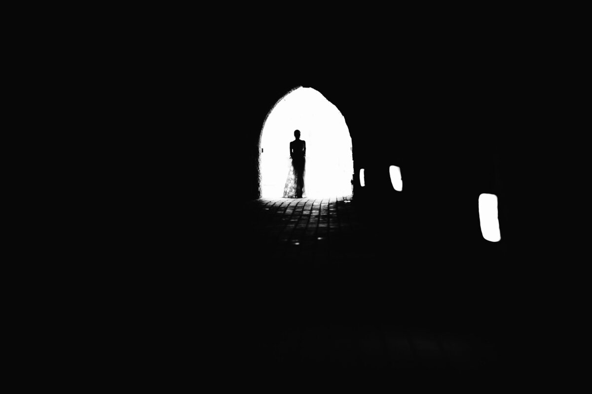 Black and white image of Groom walking alone in distance
