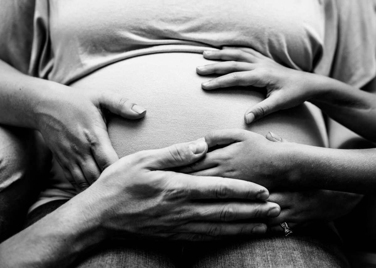 Family photography, hands on pregnant belly, black and white