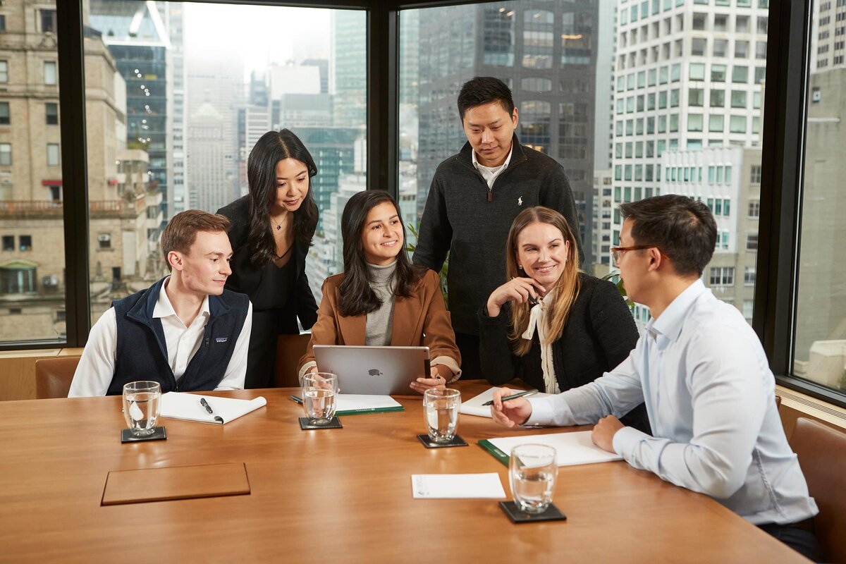 Corporate professionals collaborating in the Cornell Capital conference room, engaging in an open discussion around a conference table, captured by Ylva Erevall.