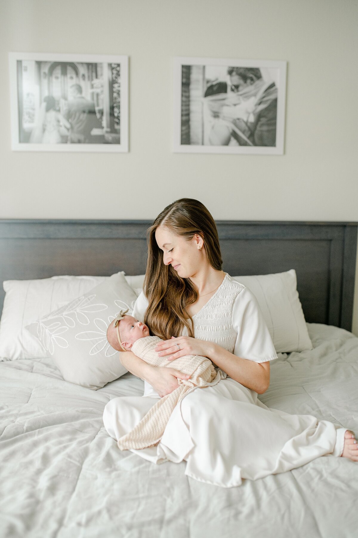 Mom holding baby in bed at lifestyle newborn shoot
