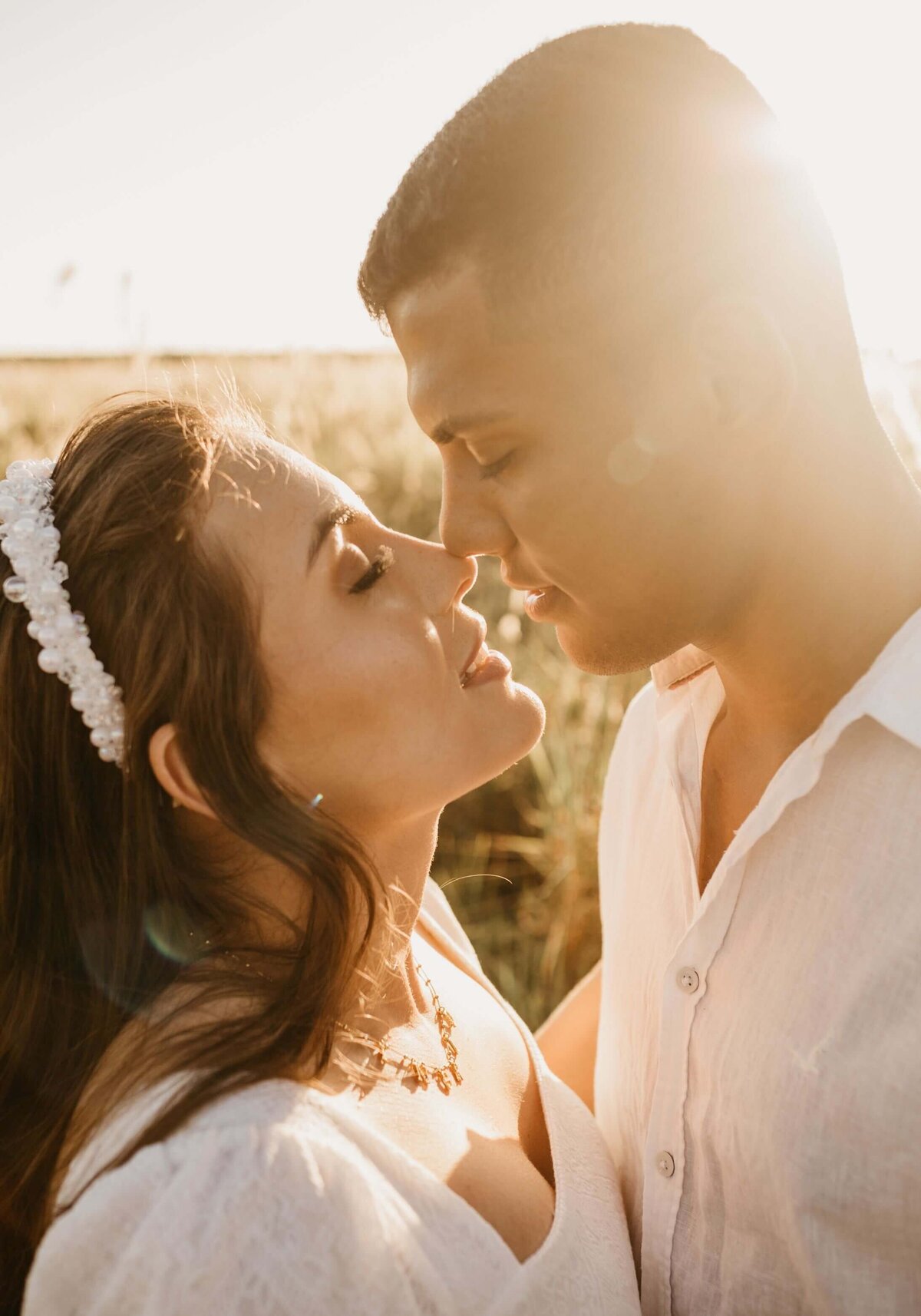 Tender couple caressing in grassy field in sunlight