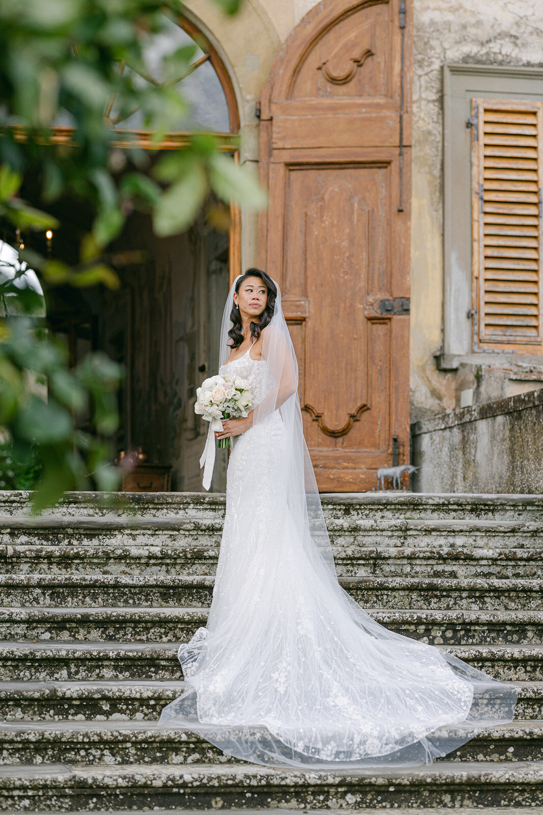 a bride standing on the steps of a building in Italy