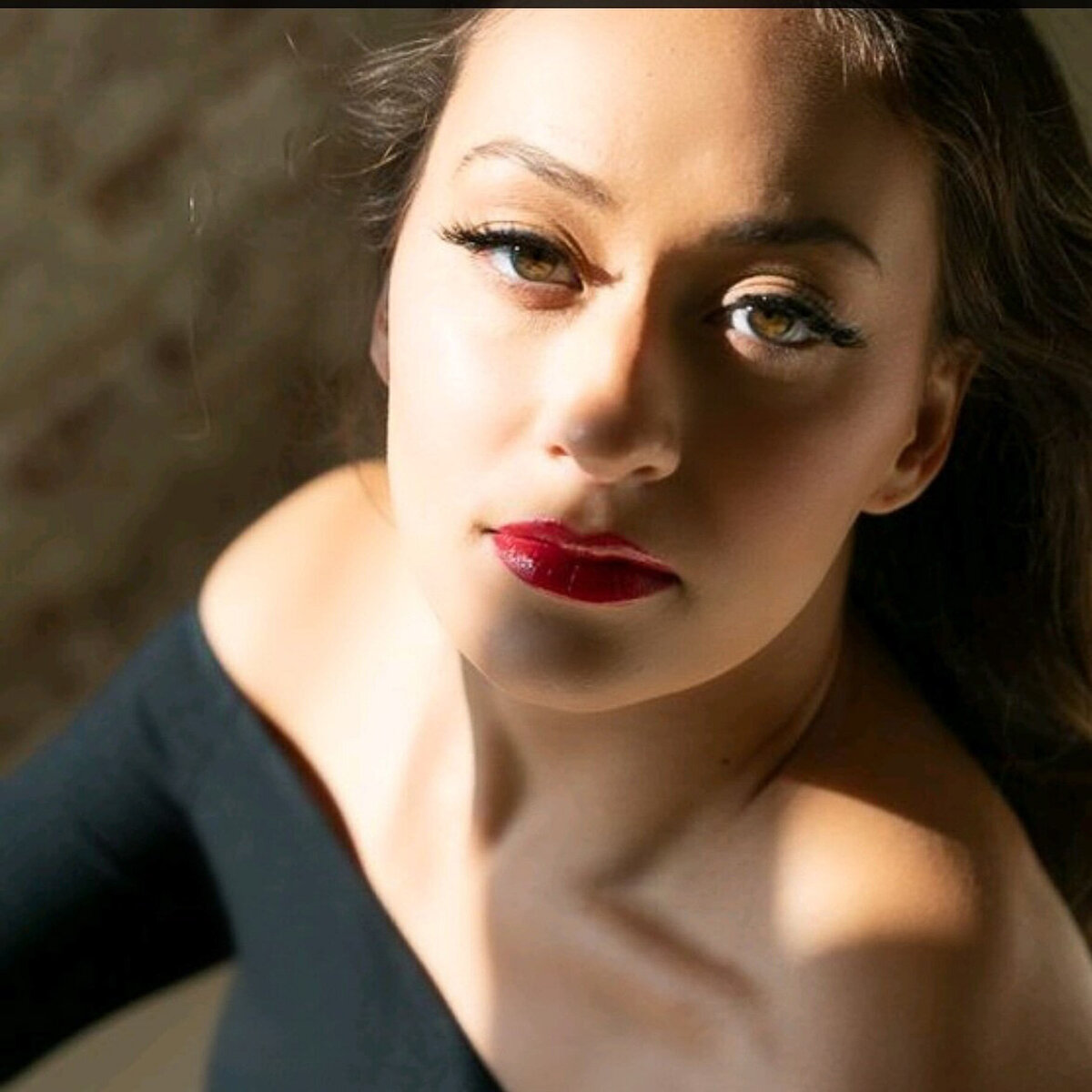 Bold red lip and glowing skin captured in a studio setting – makeup artistry by Lyds Makeup.
