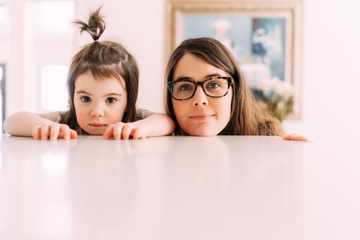 mother and daughter with chin on counter