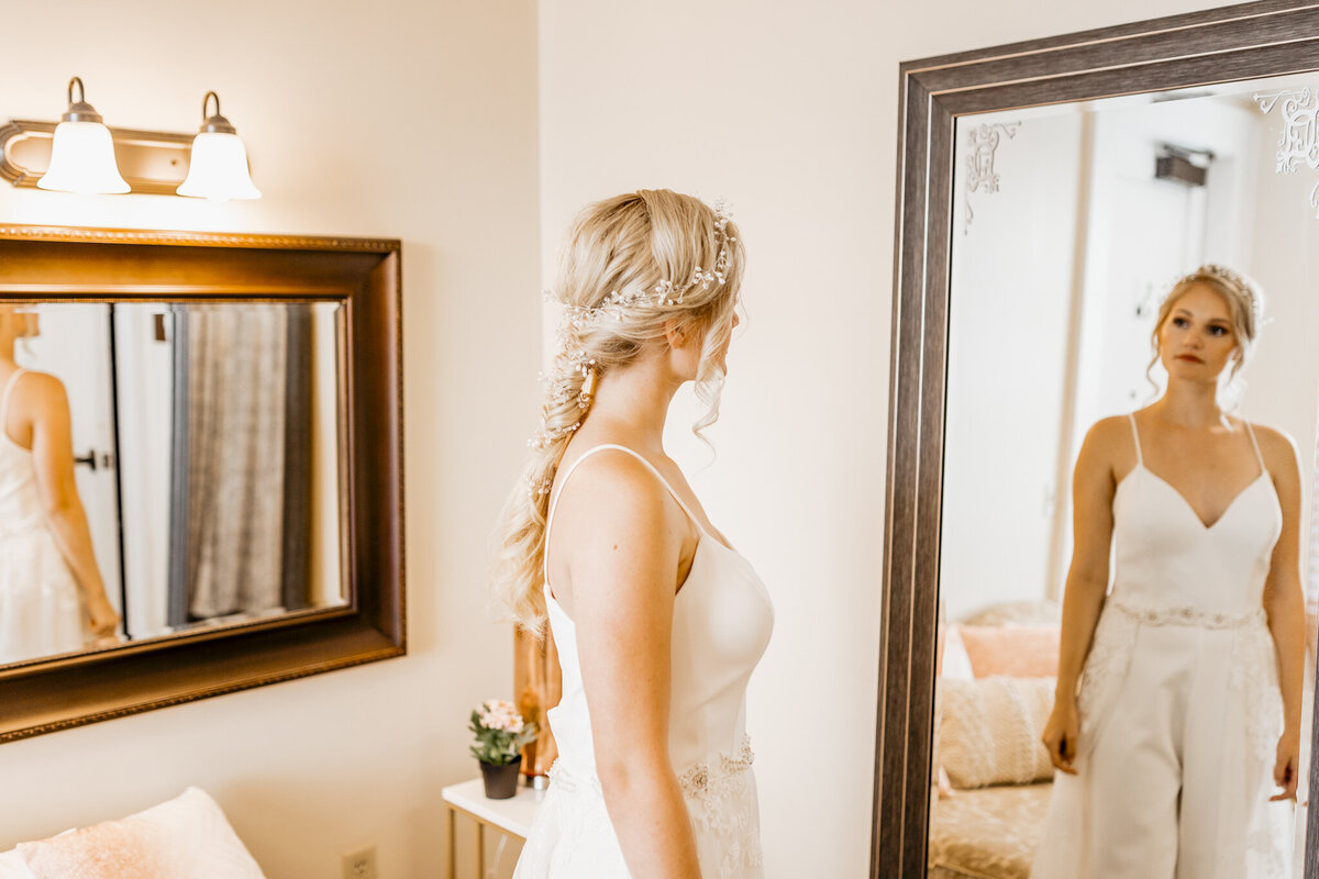 alt="bride looking in mirror at bridal suite"