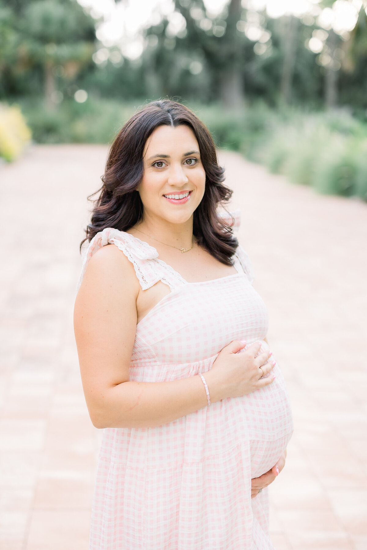 Pregnant woman in pink dress for Tampa maternity photographer Tina Marie Studio.