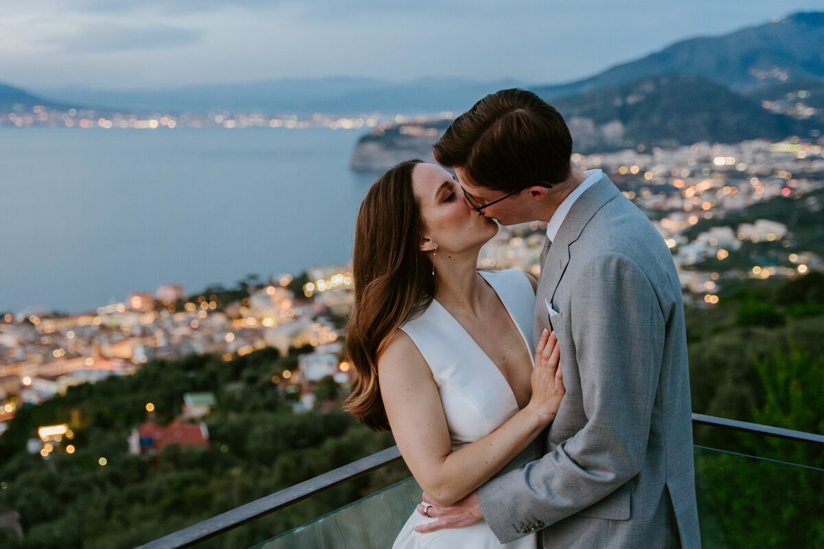 Bride and groom kissing on Sorrento terrace at sunset