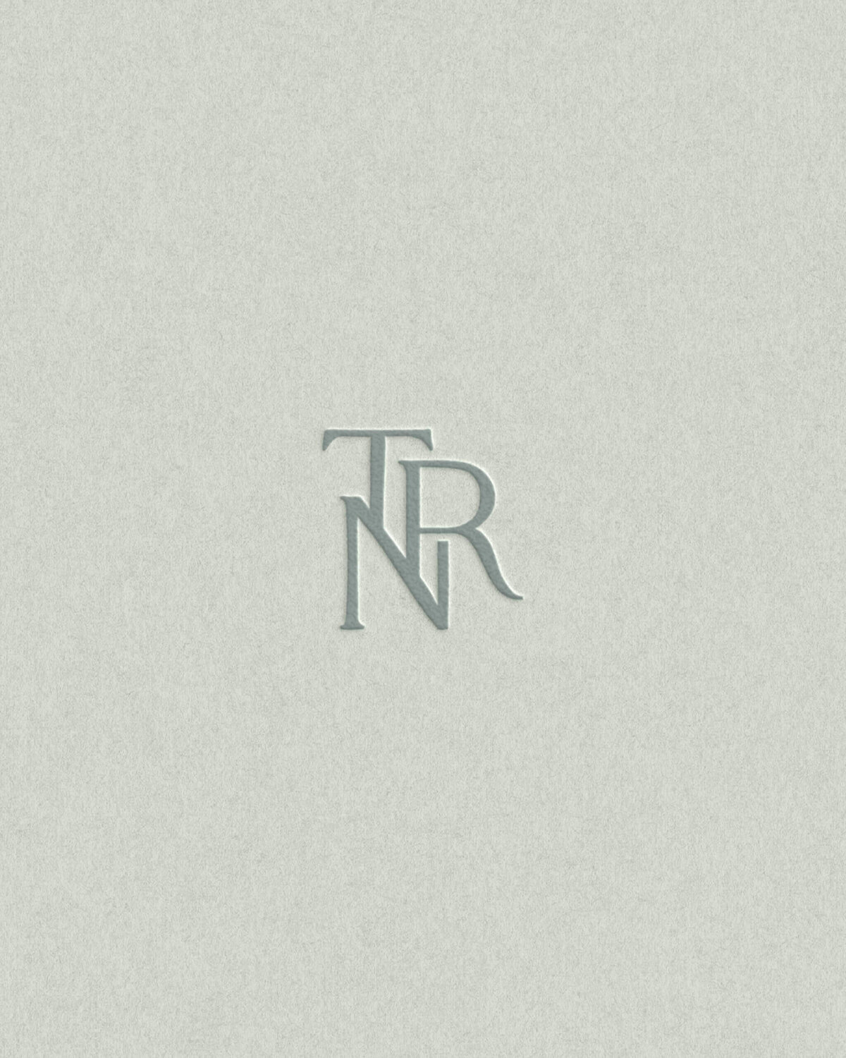 Elegant serif monogram design with muted sage backdrop, perfect for timeless, high-end artisan and lifestyle brands.