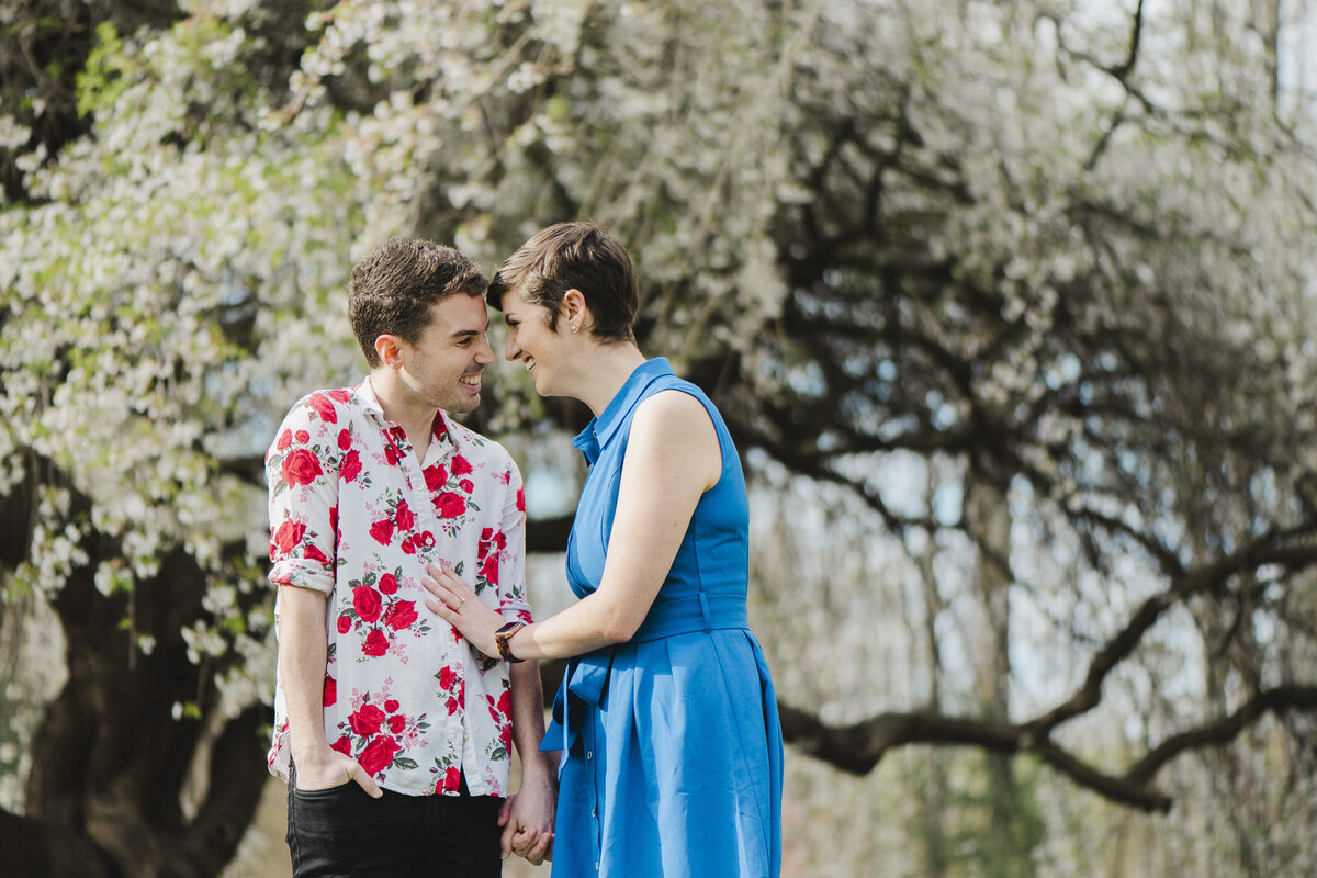 A couple smiles cheekily at one another outdoors at Brookside Gardens.