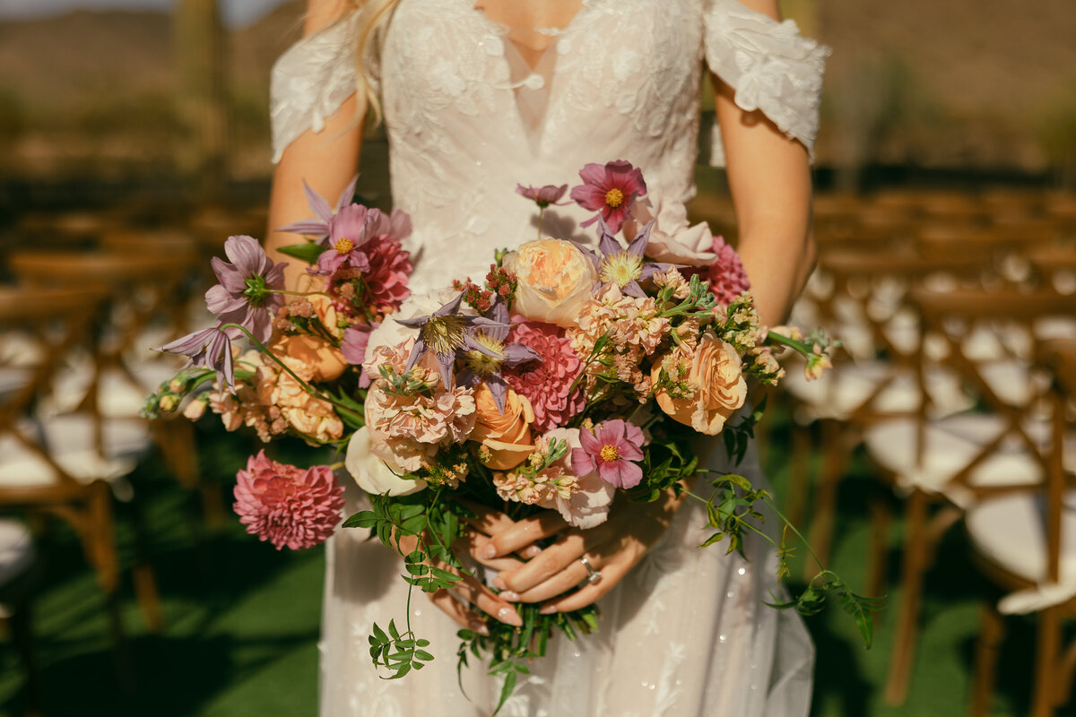 a bride holds her colorful bouquet