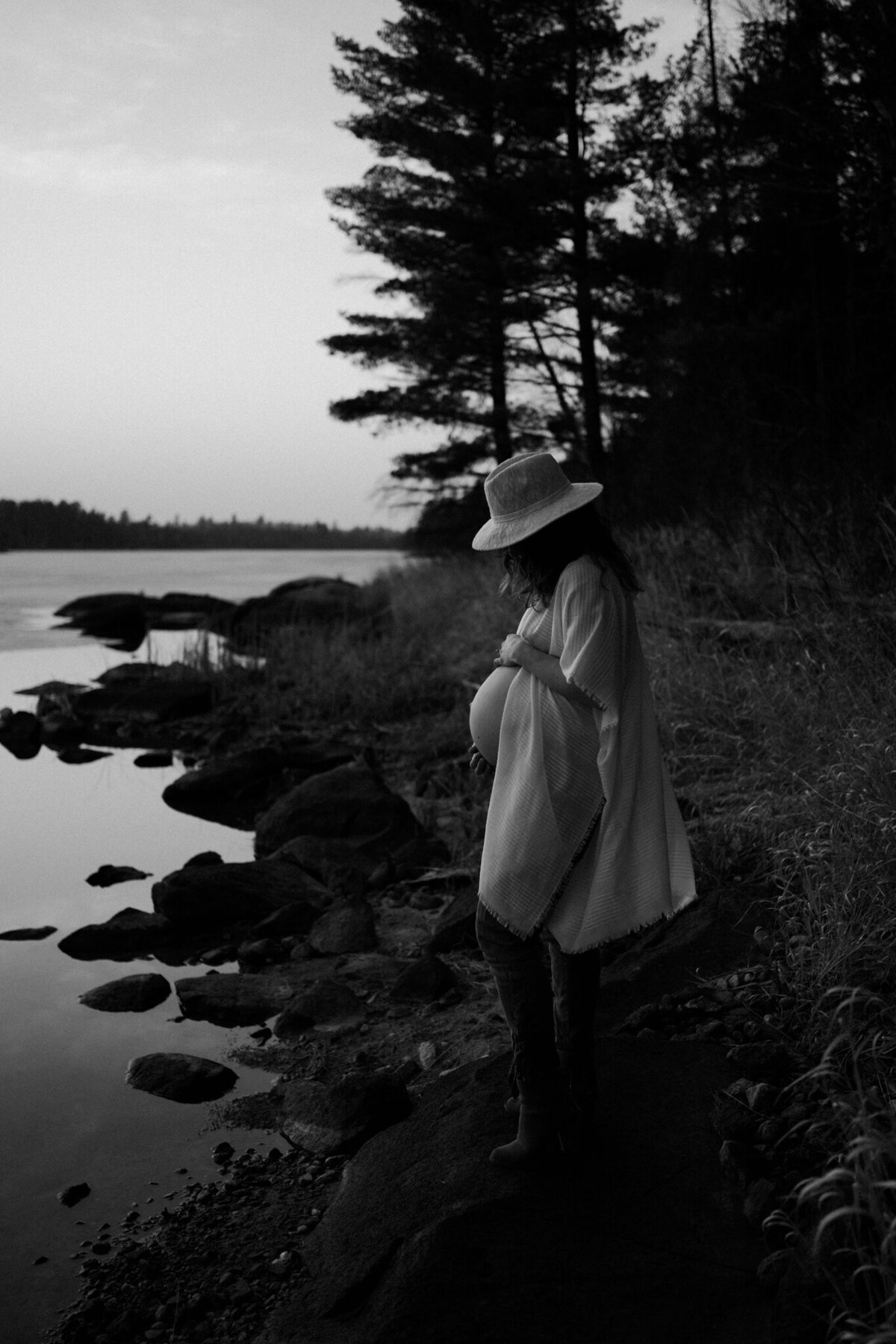 black and white image pregnant woman by lake