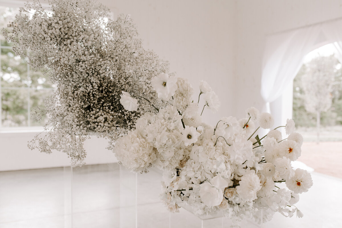 Gorgeous white floral installation in white open warehouse wedding venue