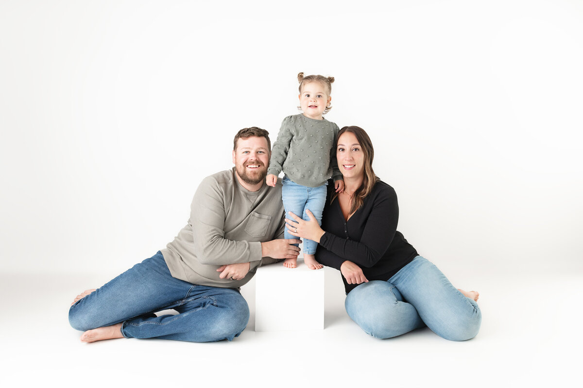 Studio family portrait with little girl posing between parents | Paris Ontario studio in Paris, Ontario