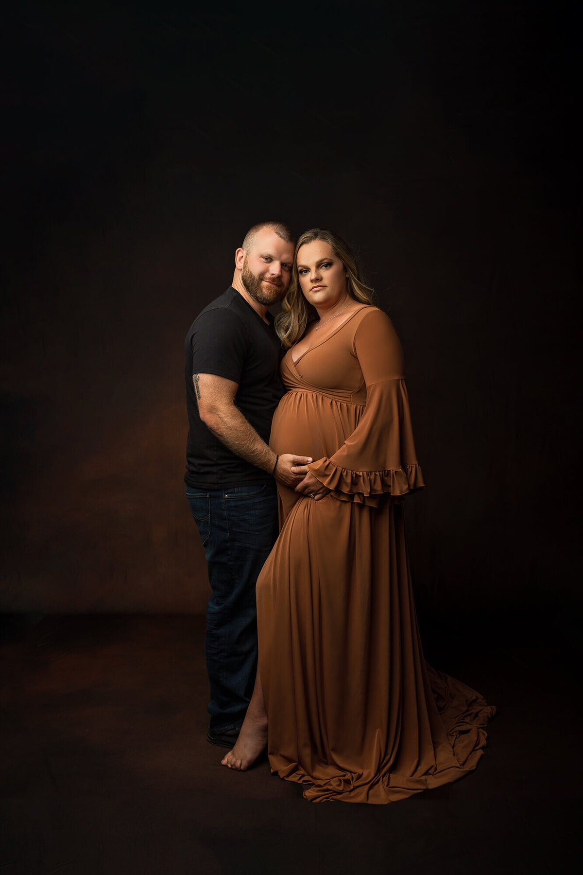 Expecting Parents pose for the camera during their couples maternity session in Minnesota.