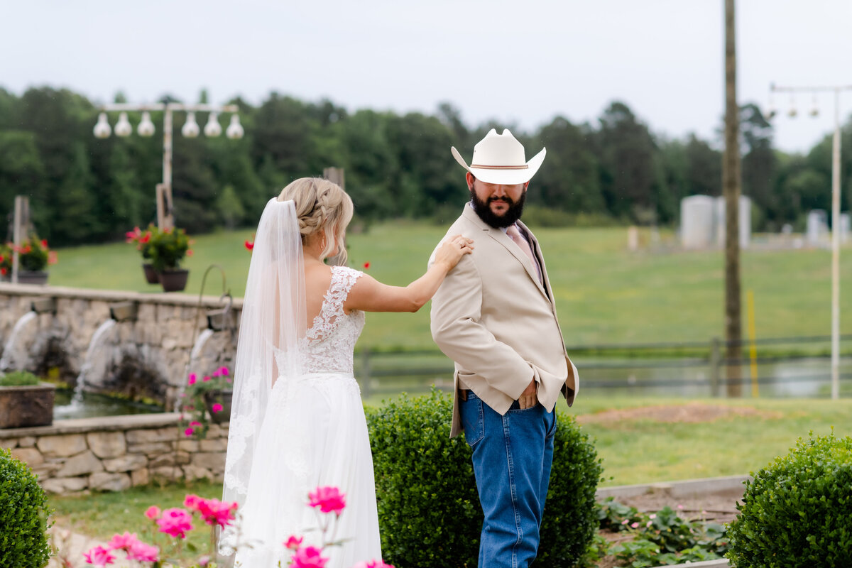 Little Rock wedding photographer photographs first look between bride and groom as they stand in a rose garden before their wedding venue