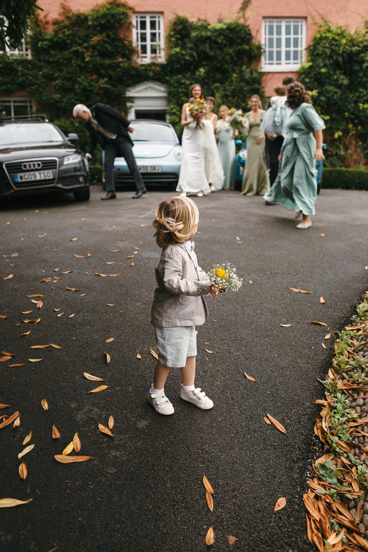 Mini grromsman leads the way to the wedding 