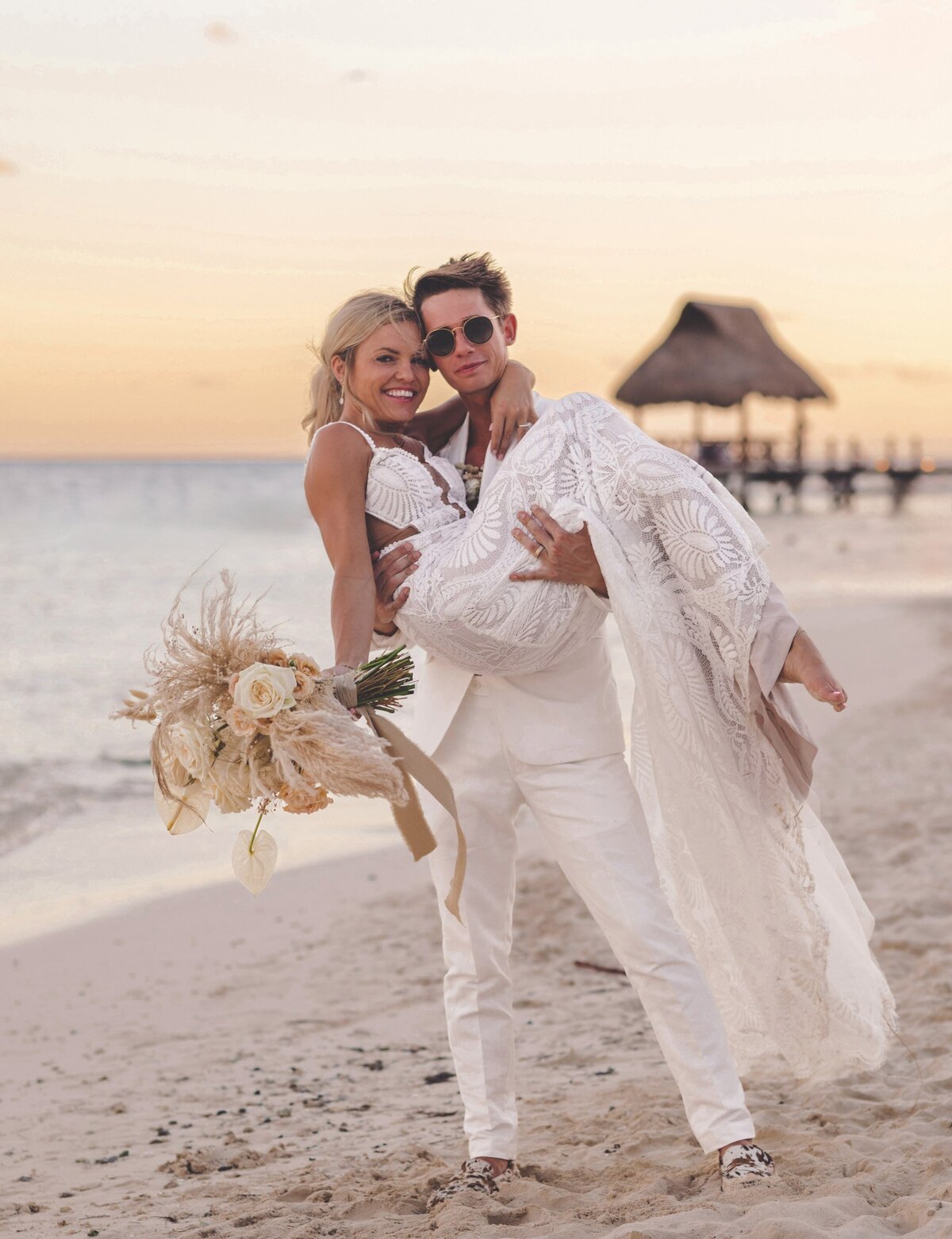 Groom holding bride on beach at  viceroy riviera maya wedding
