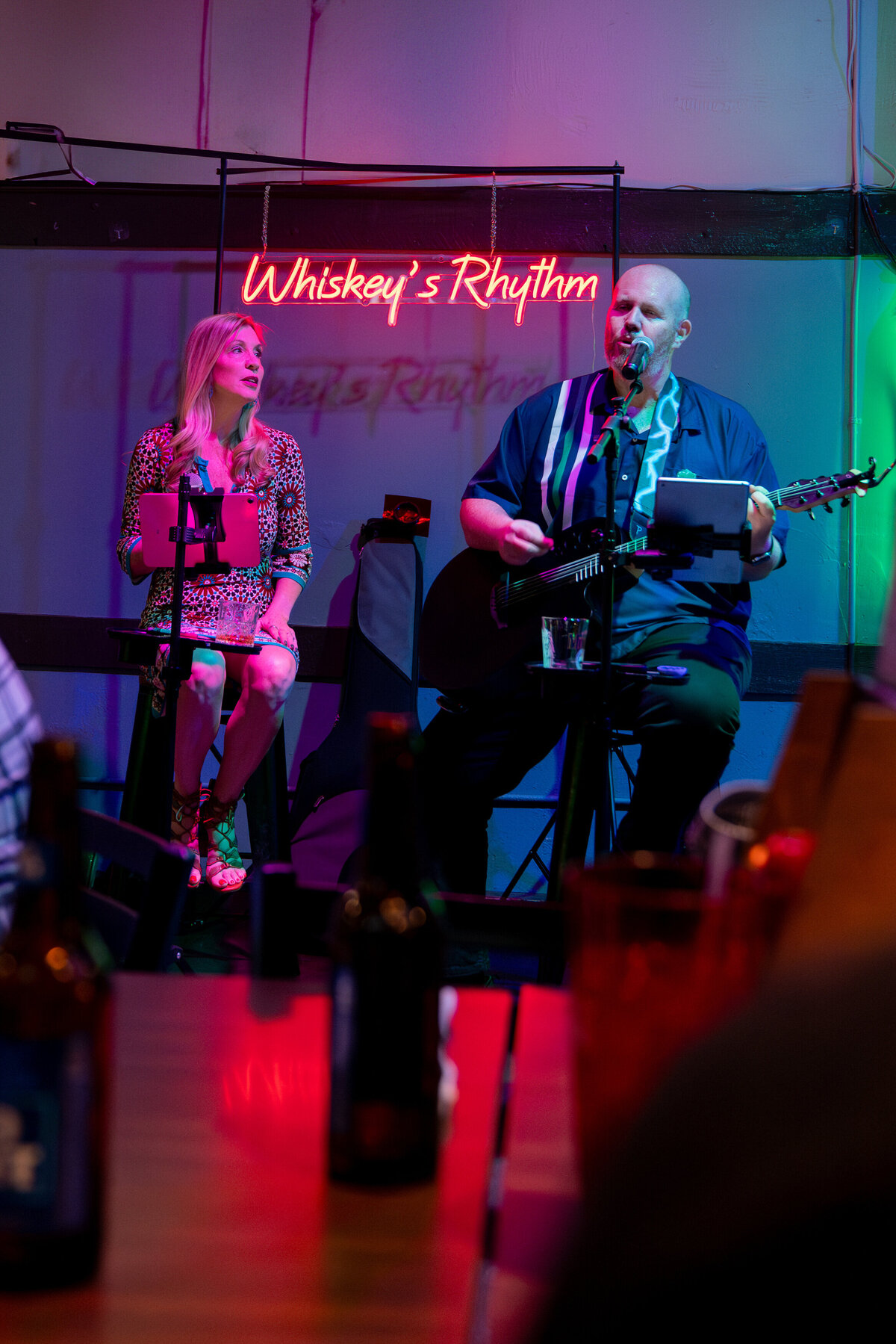Two people singing together on a small stage 