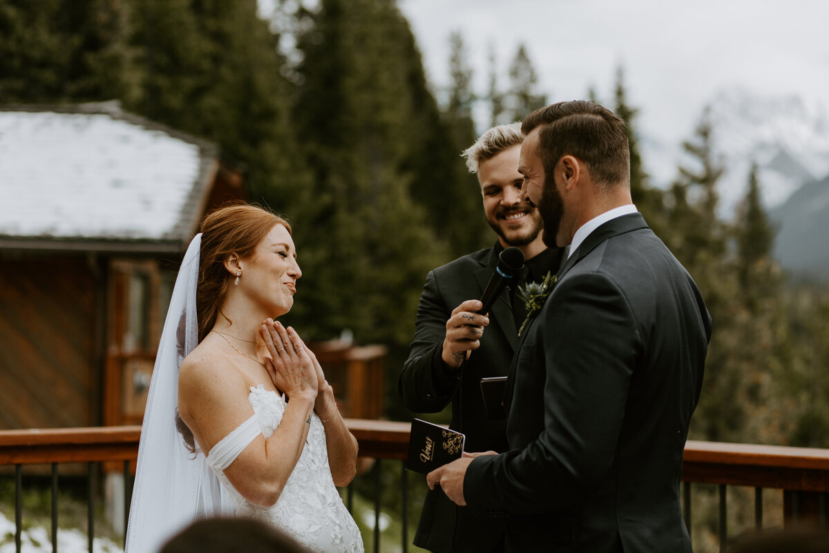 Stunning red haired bride smiling at her groom during their outdoor wedding ceremony captured by Tim & Court Photo and Film, joyful and adventurous wedding photographer and videographer in Calgary, Alberta. Featured on the Bronte Bride Vendor Guide.