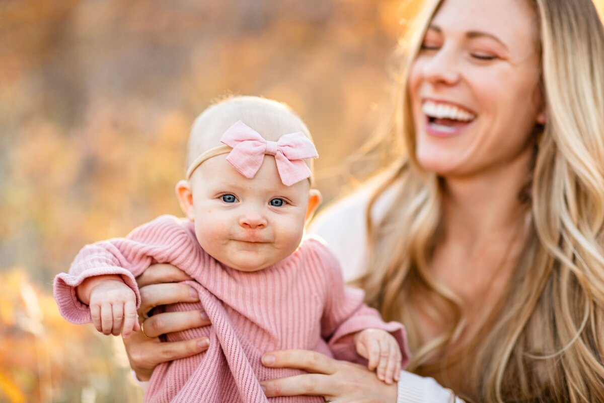a woman laughing and holding her baby
