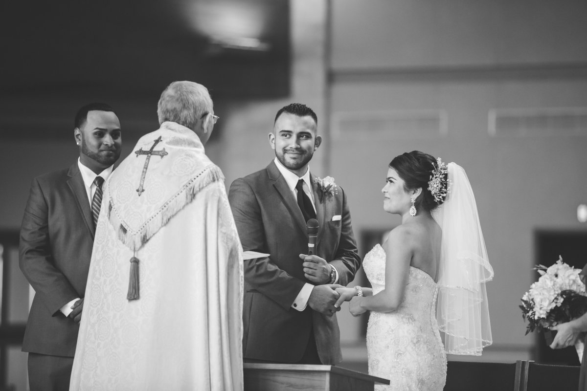 Couple holding hands at altar during wedding ceremony at St. Anthony Claret Catholic Church San Antonio